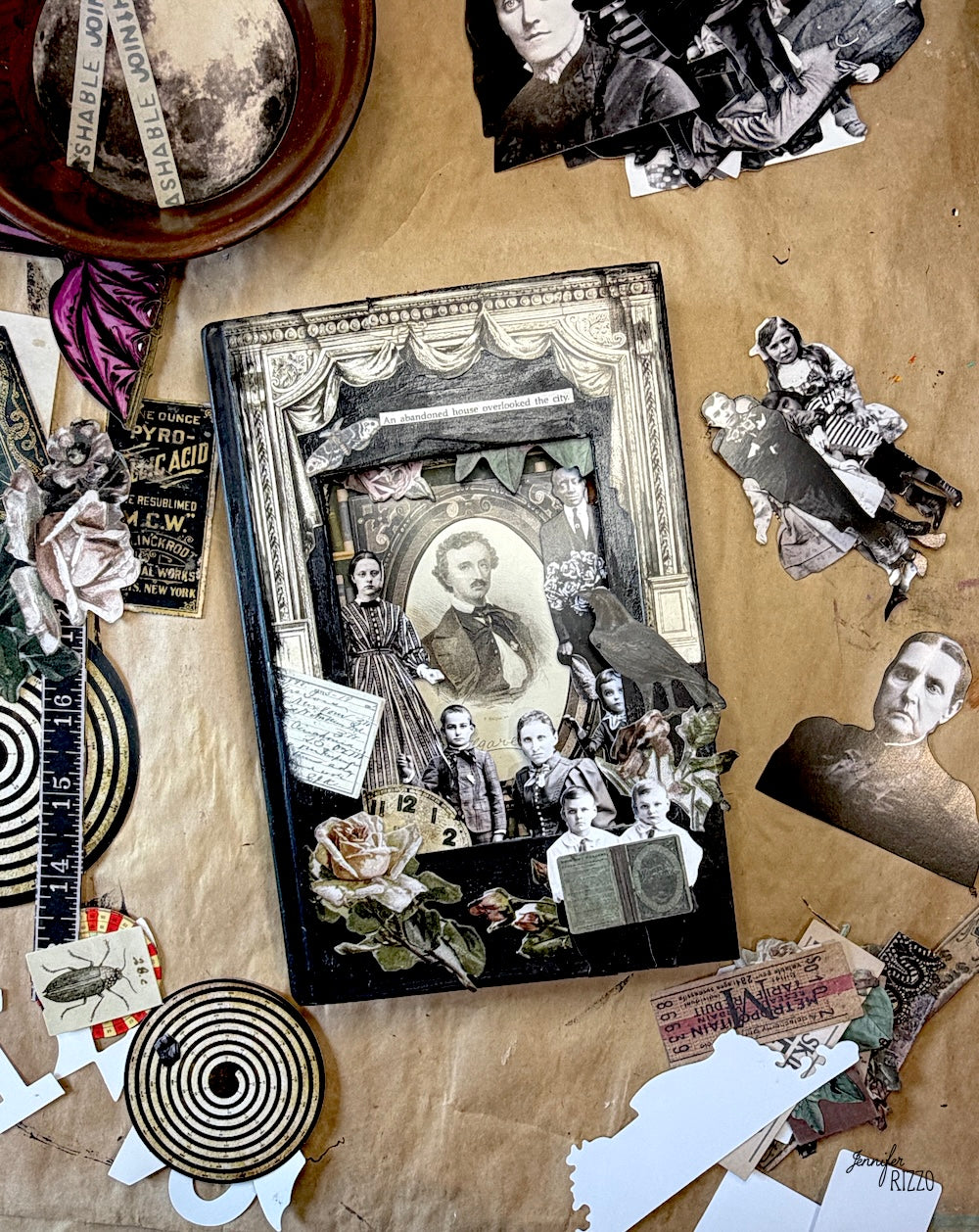 A vintage-style collage book or album cover featuring sepia-toned portraits, torn paper cutouts, handwritten notes, and decorative collage elements, arranged on a brown paper surface with additional scrapbook materials around it.