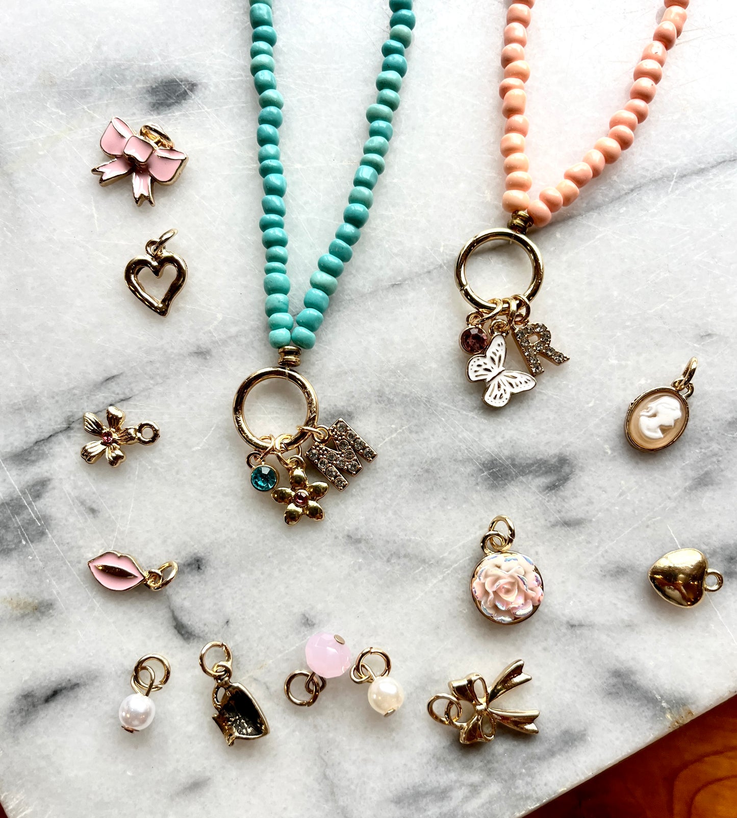 Collection of various jewelry charms on a marble surface