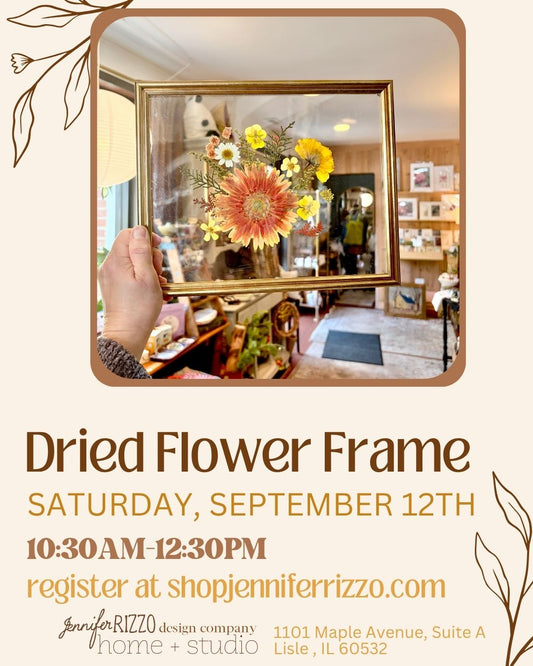 A hand holding a gold frame with dried flowers with a shop background for a graphic for a dried flower frame workshop
